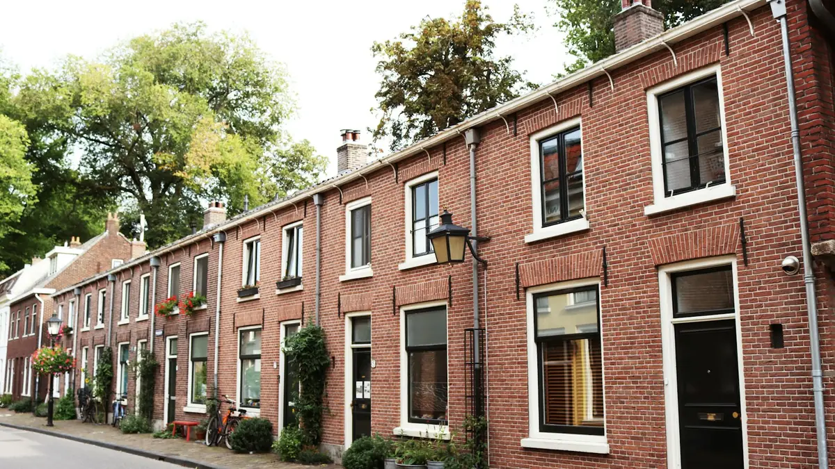 Rij Nederlandse bakstenen rijtjeshuizen in een rustige straat